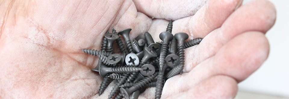 Schrauben in einer Hand